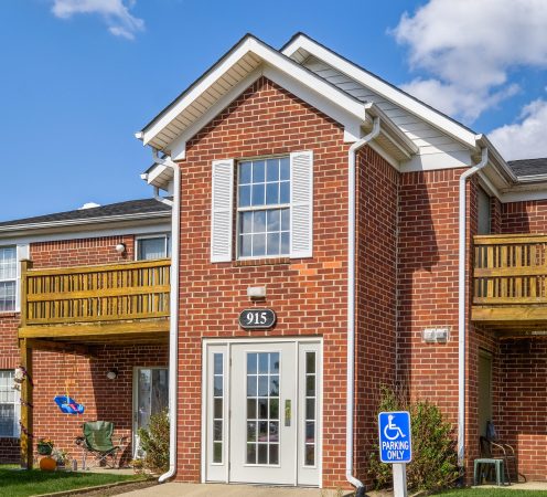 Exterior image of apartment building with a handicap parking sign