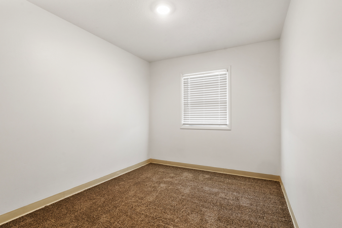 Bedroom with white walls, a window, and grey carpet
