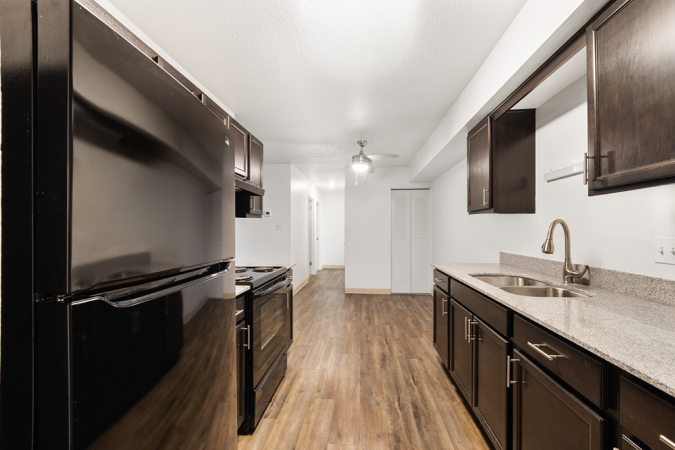 Kitchen with vinyl floor, black cabinets, and black appliances
