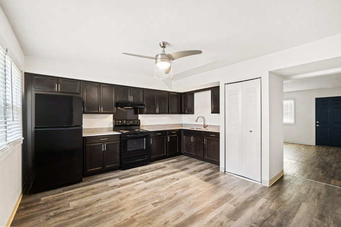 Kitchen with vinyl floor, black cabinets, and black appliances