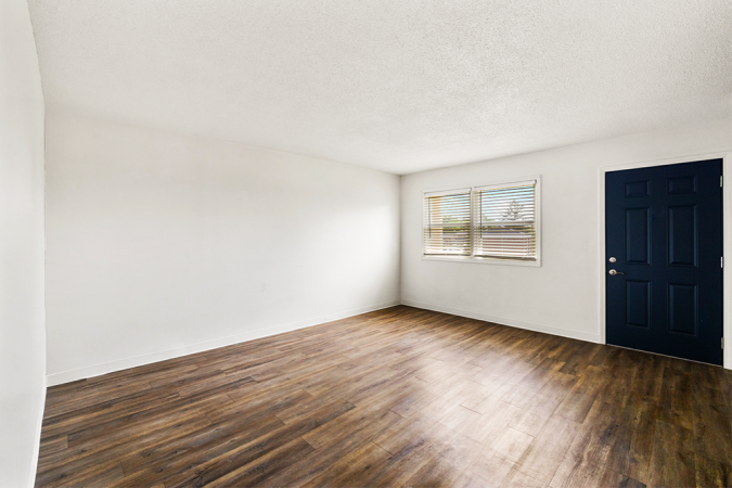 Living room with vinyl floor and white walls