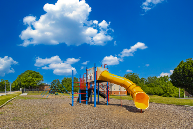 playground with a yellow slide and swings