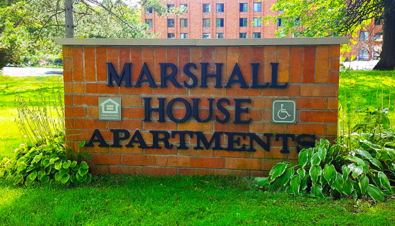 Brick sign reading Marshall House Apartments